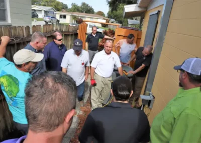 An instructor shows the outside of a home to several home inspection students