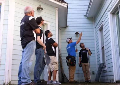 A home inspector trains four students on site at a home